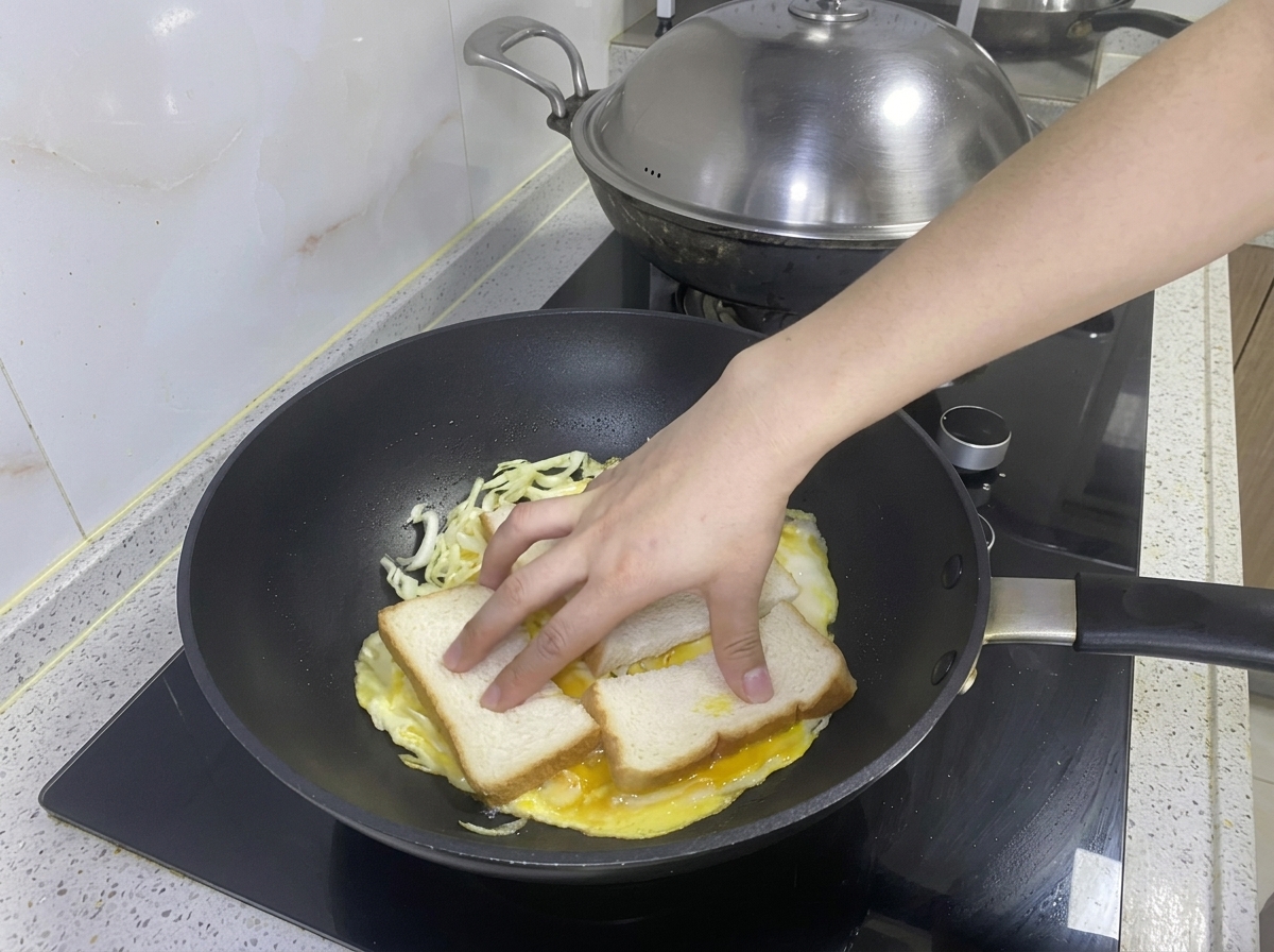 Two slices of bread placed onto the egg and cabbage omelet in the pan.