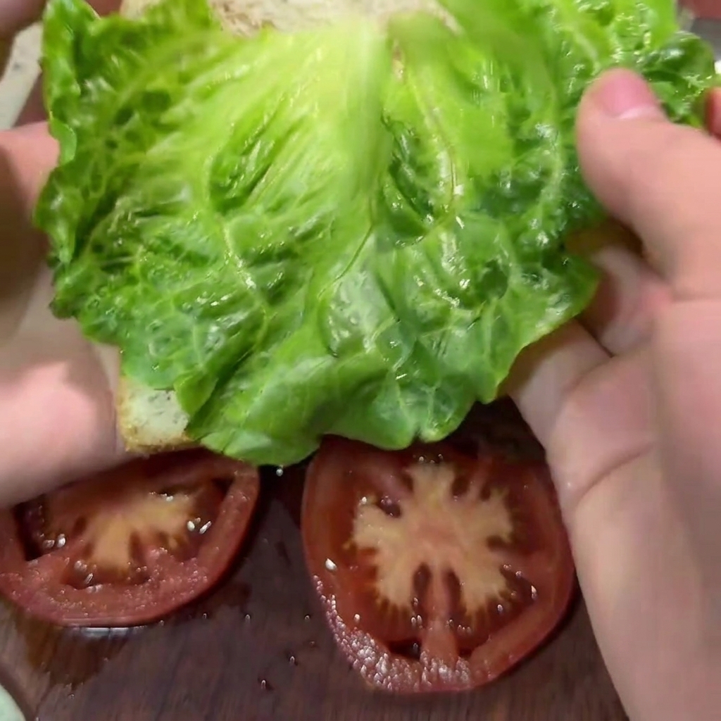 A wooden spoon mixing the minced beef, broccoli, and carrot mixture in a large white bowl.