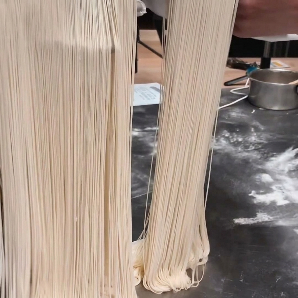 A bowl of flour on a scale with salt and alkaline powder ready to be mixed.