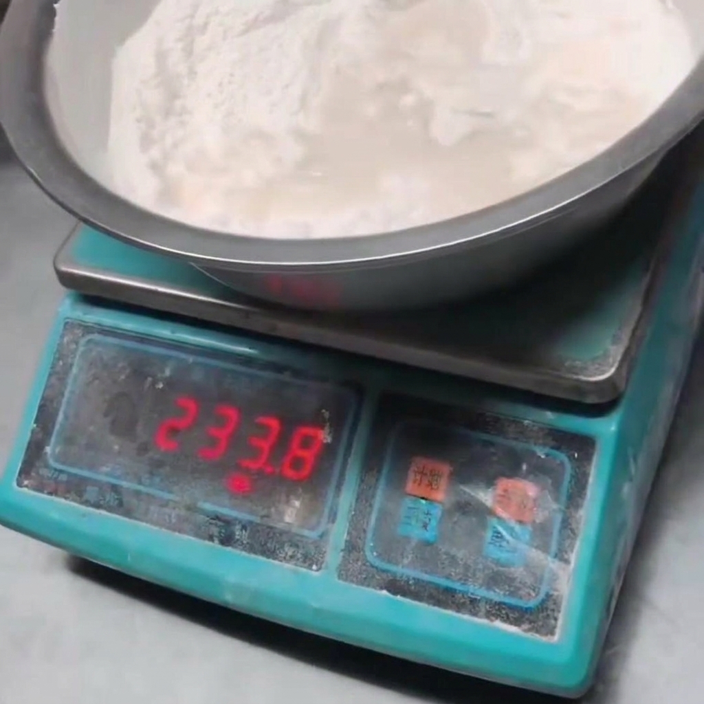 Cold water being poured into the bowl of flour.