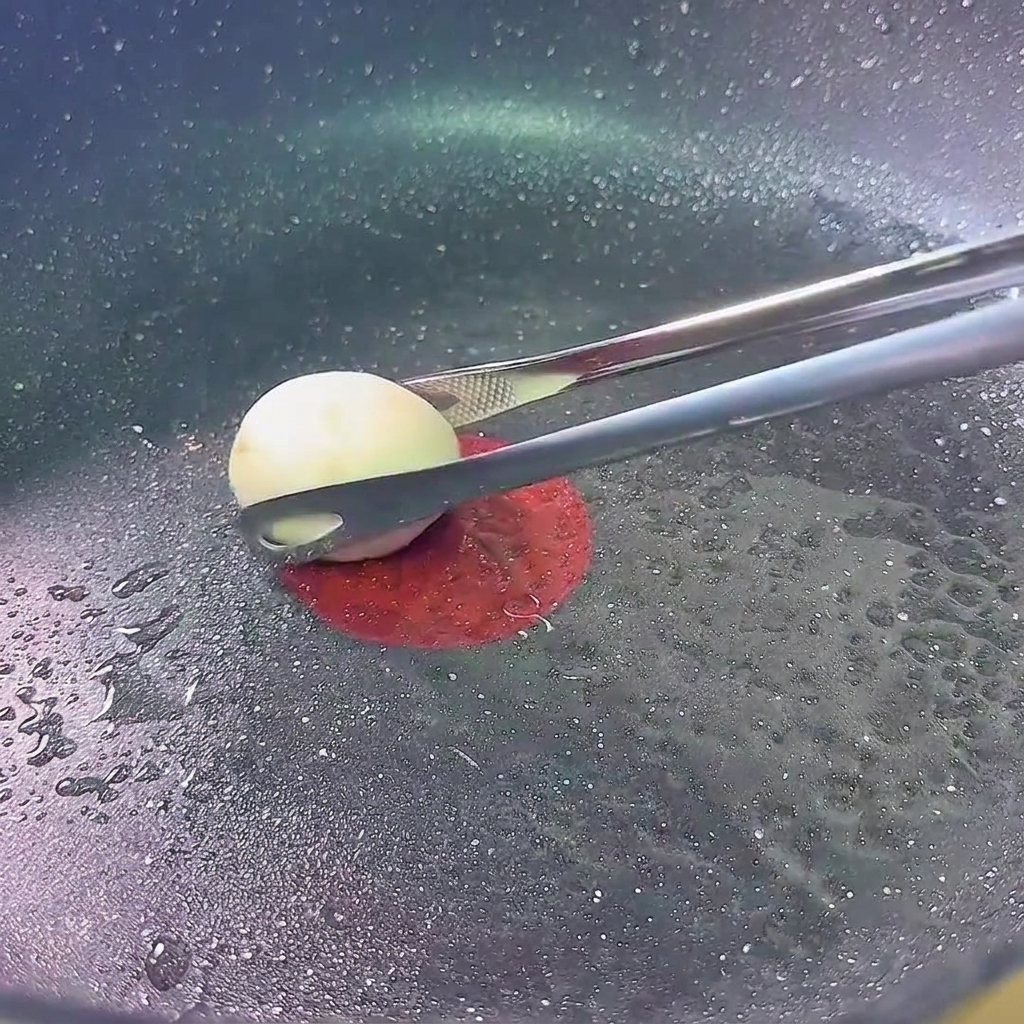 Mushroom caps browning in a pan over low heat.