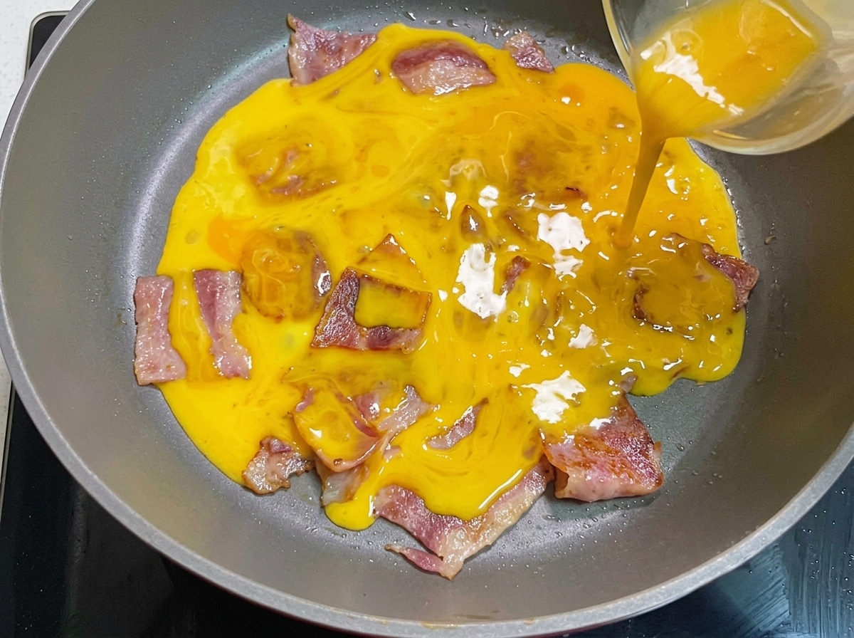 Buttered burger buns toasting in a pan until golden brown.