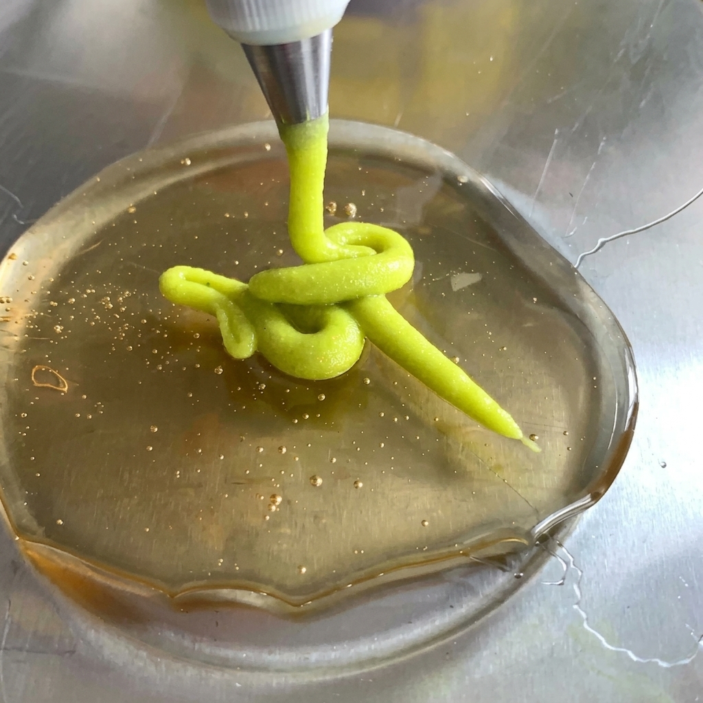 A dollop of mayonnaise being added to the sauce mixture in the bowl.