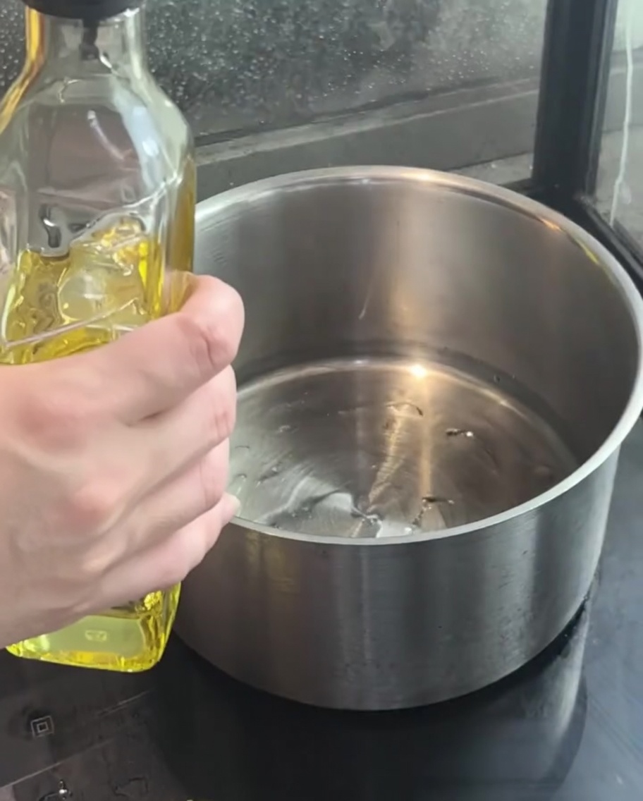Diced purple onions sizzling in hot oil inside a pot.