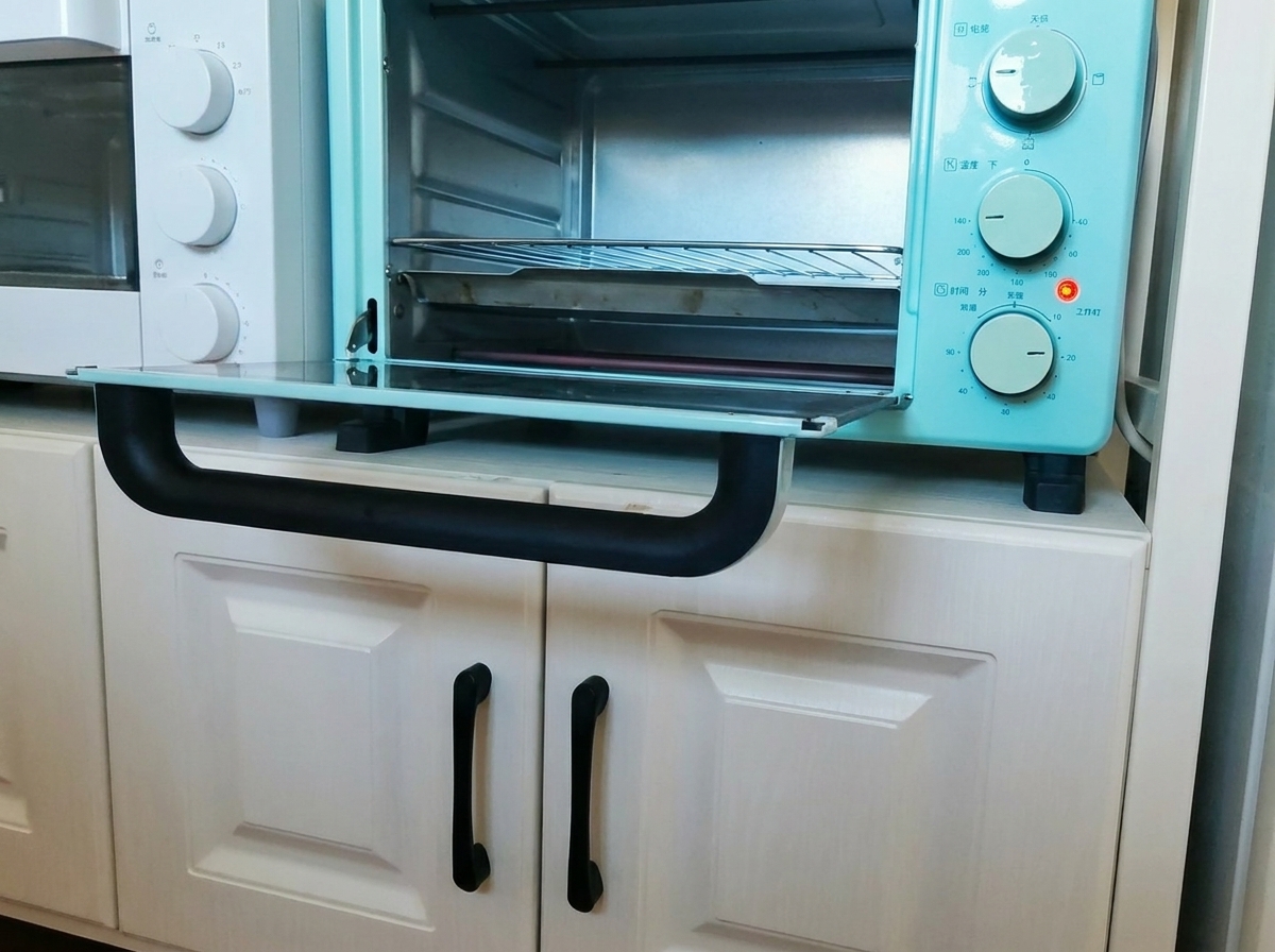 The glazed pork ribs on a baking tray being inserted into a small teal-colored countertop oven.