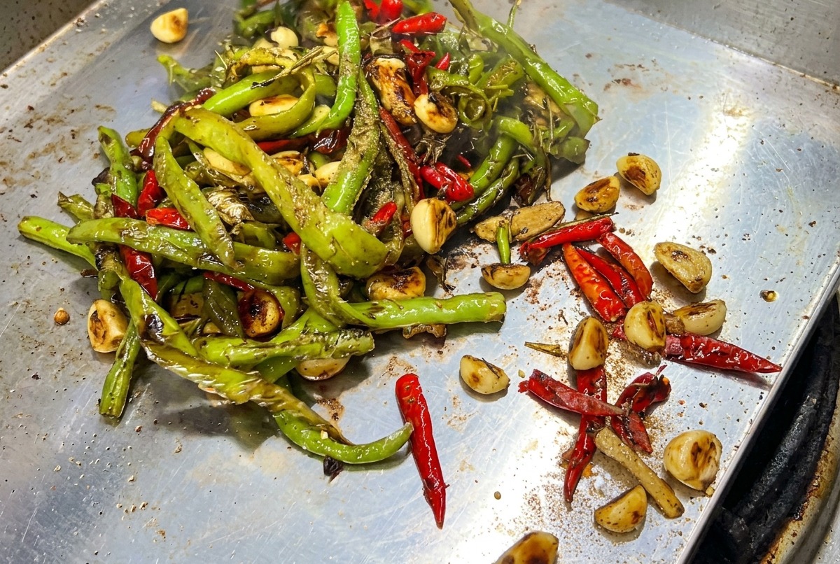 Ingredients being mixed with a spatula on the hot griddle.