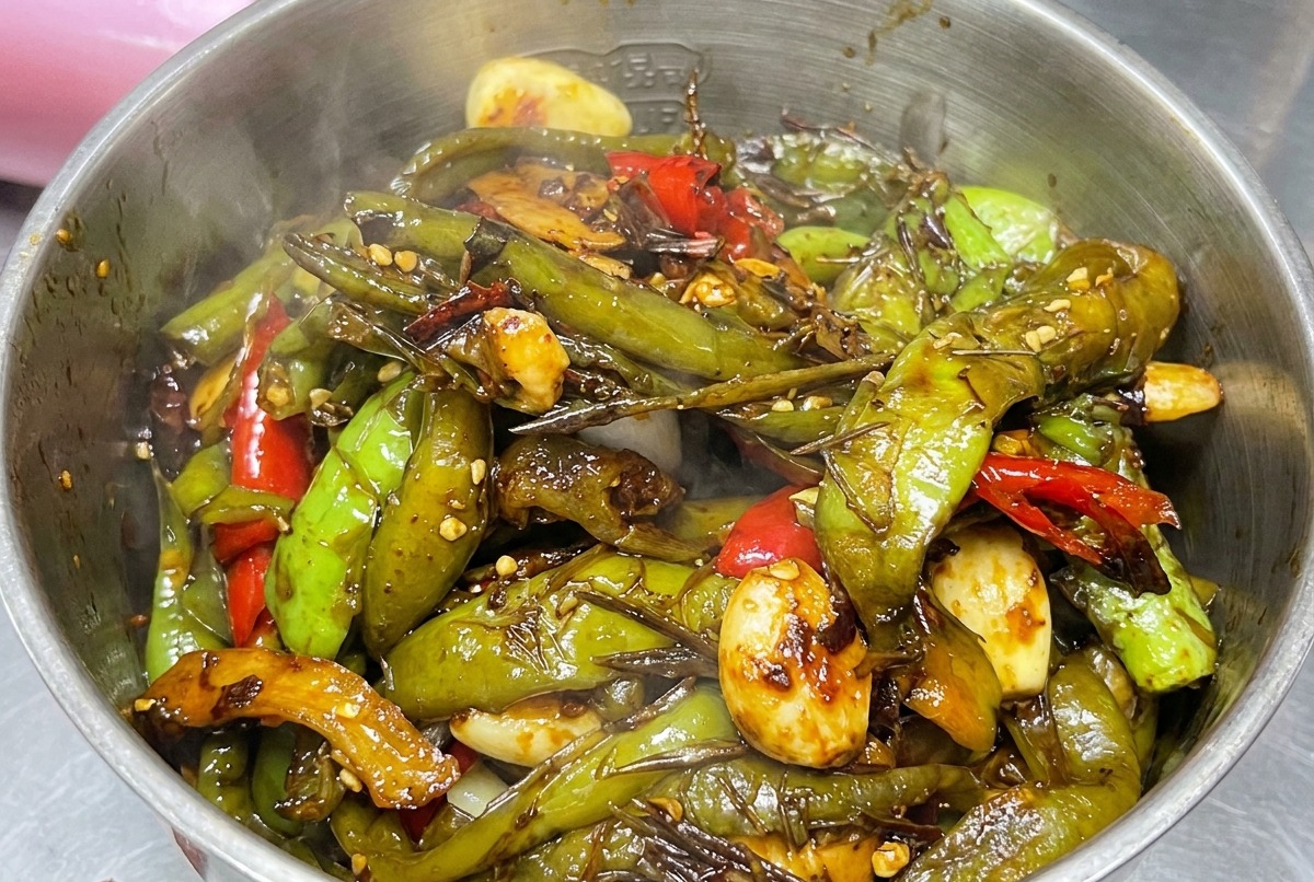 Cooked pepper mixture being placed into a blender.