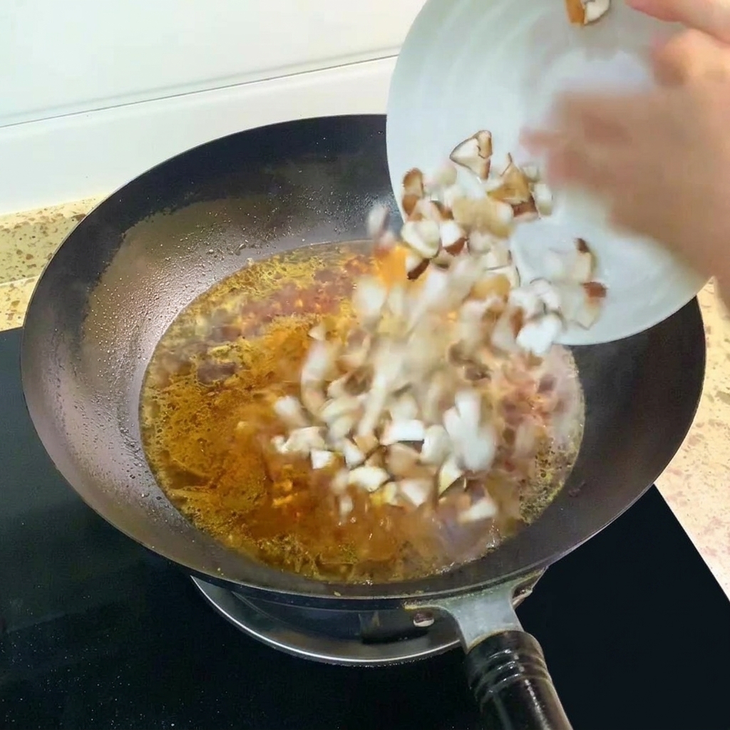 Diced shiitake mushrooms being added to the bubbling soup in the wok.