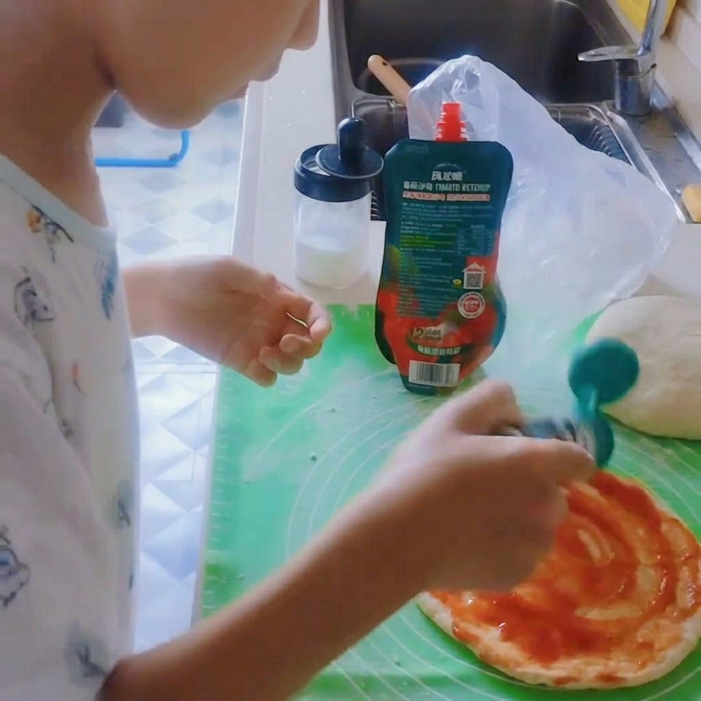 Black pepper being added to the sauce-covered pizza base.