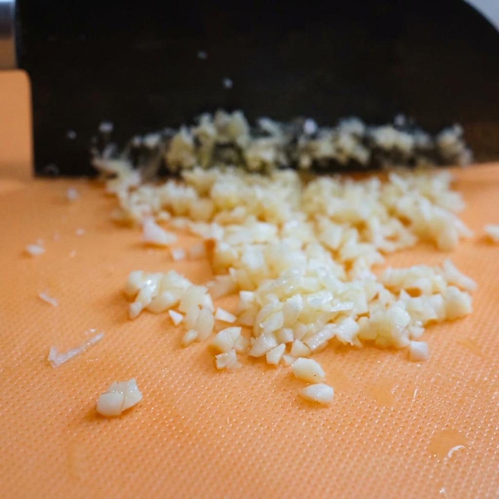 Freshly grated Parmesan cheese piles resting on a cutting board after being processed.