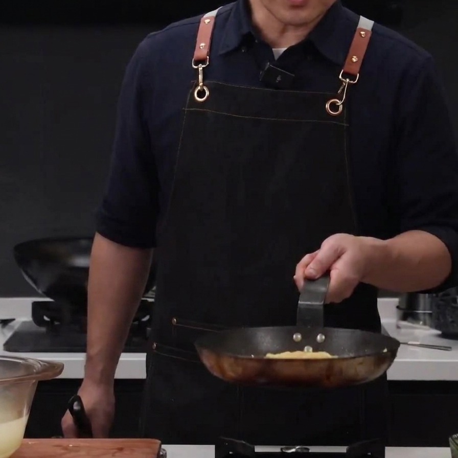 Pasta water being poured over chicken and spaghetti in a pan to loosen the texture.