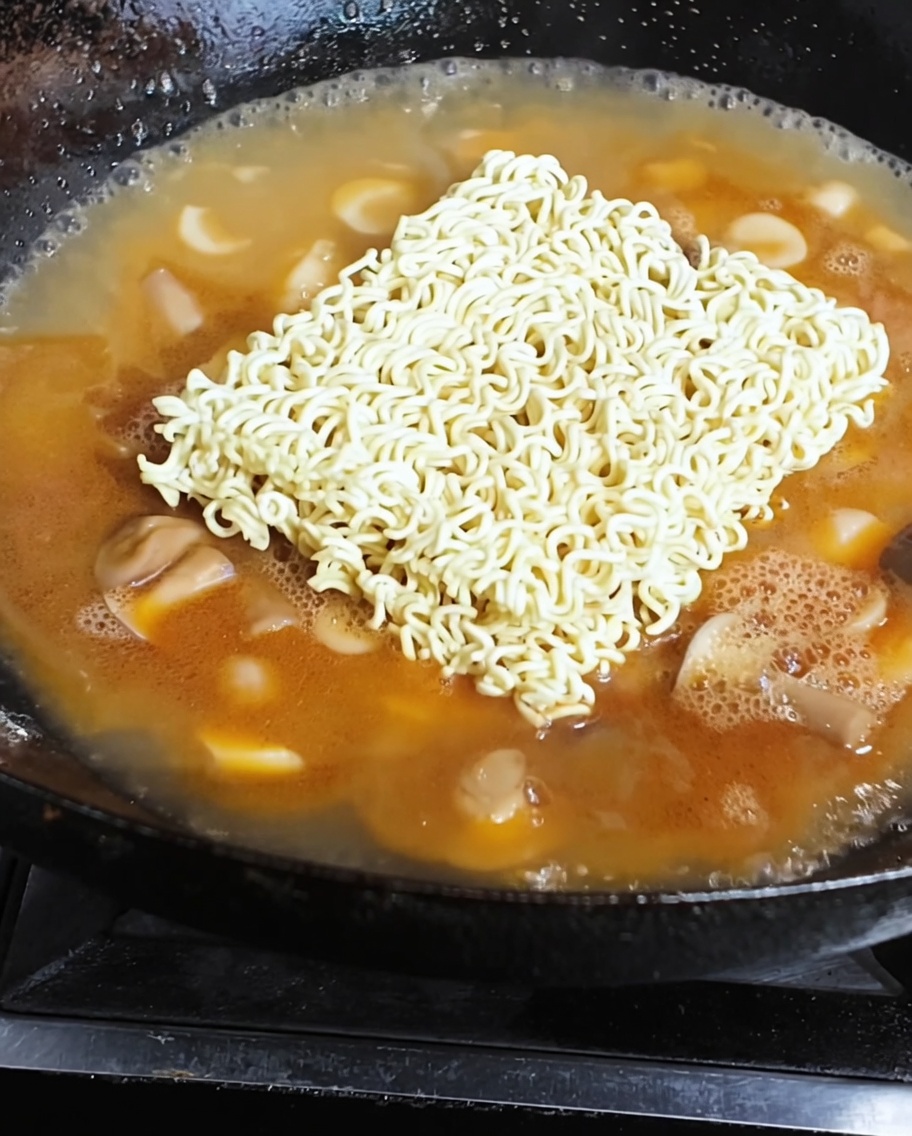 Instant noodles and a fried egg simmering in a rich, flavorful broth.