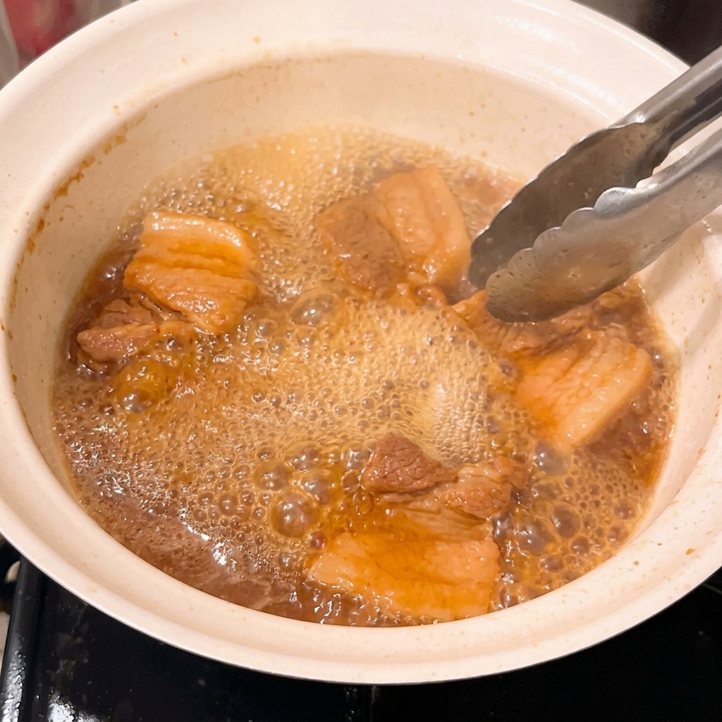 Close-up of tender pork pieces simmering in a thickened, bubbling miso glaze.