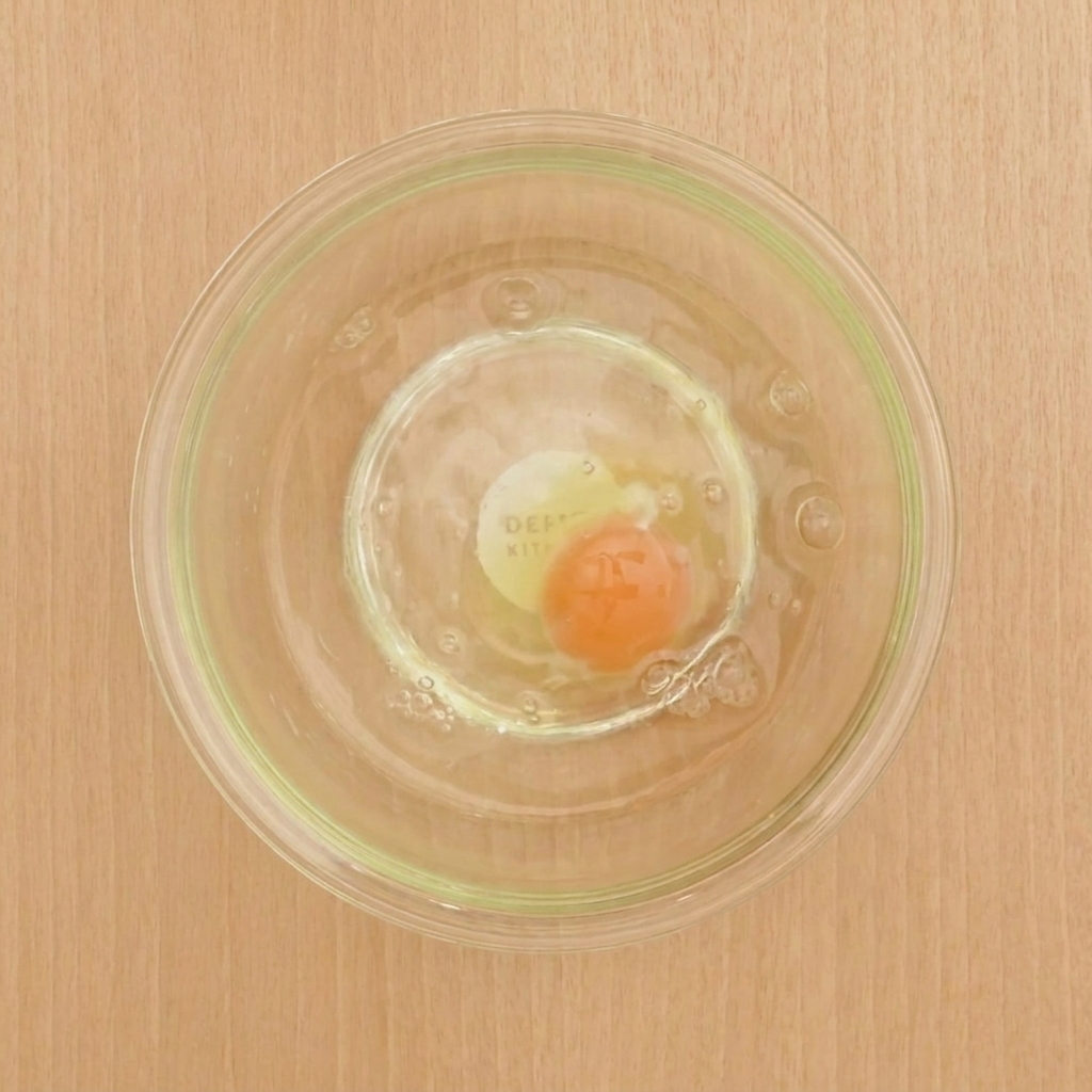 A bowl containing the mixed egg, cold water, flour, and starch, creating a smooth tempura batter.