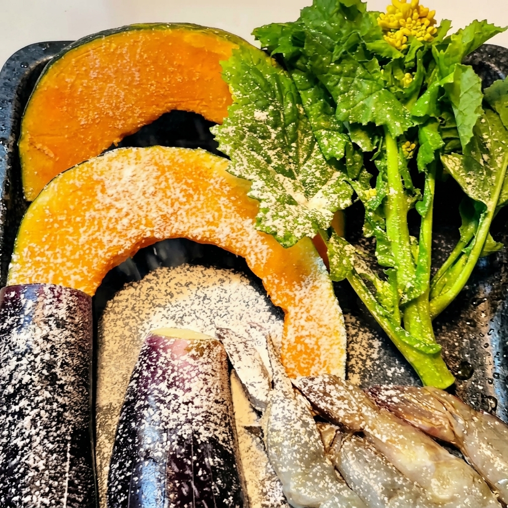 Pumpkin slices, eggplant pieces, and raw shrimp dusted with a fine layer of flour on a baking sheet.