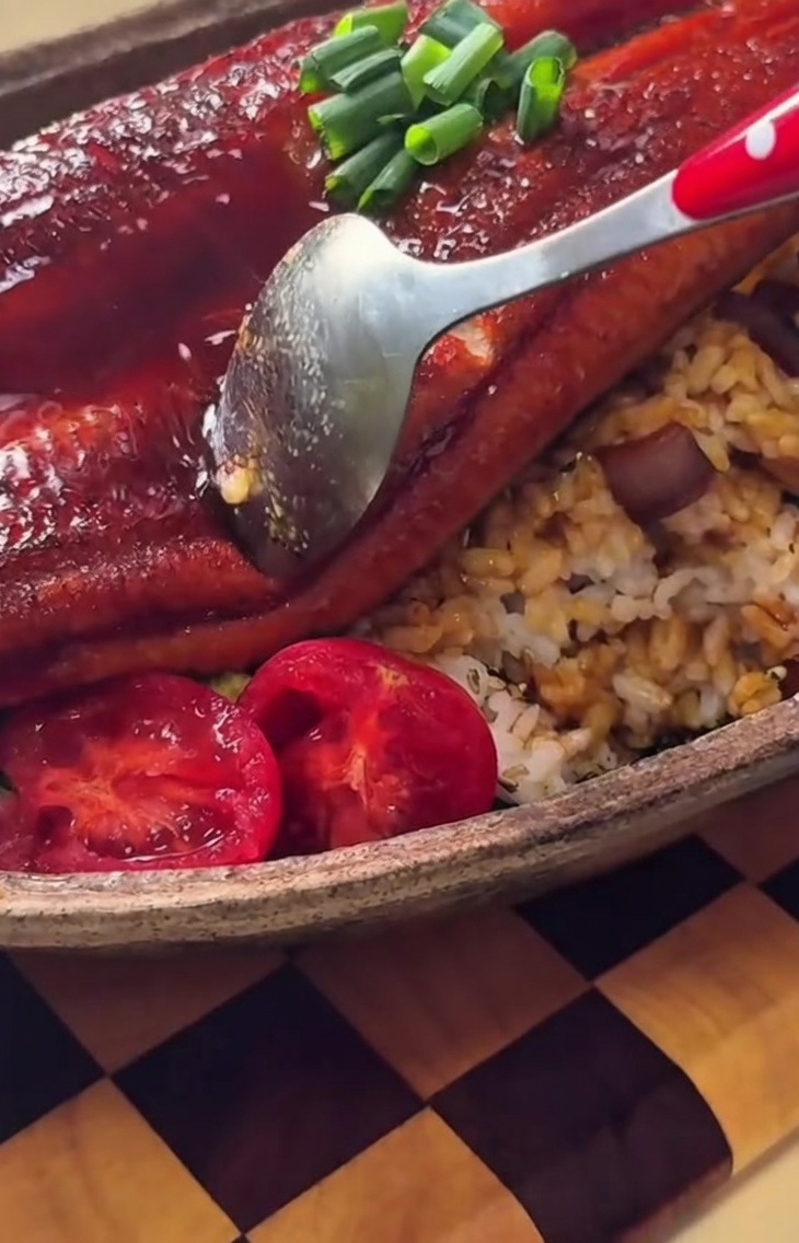 A neatly molded mound of white rice inverted onto the center of an oval ceramic plate.