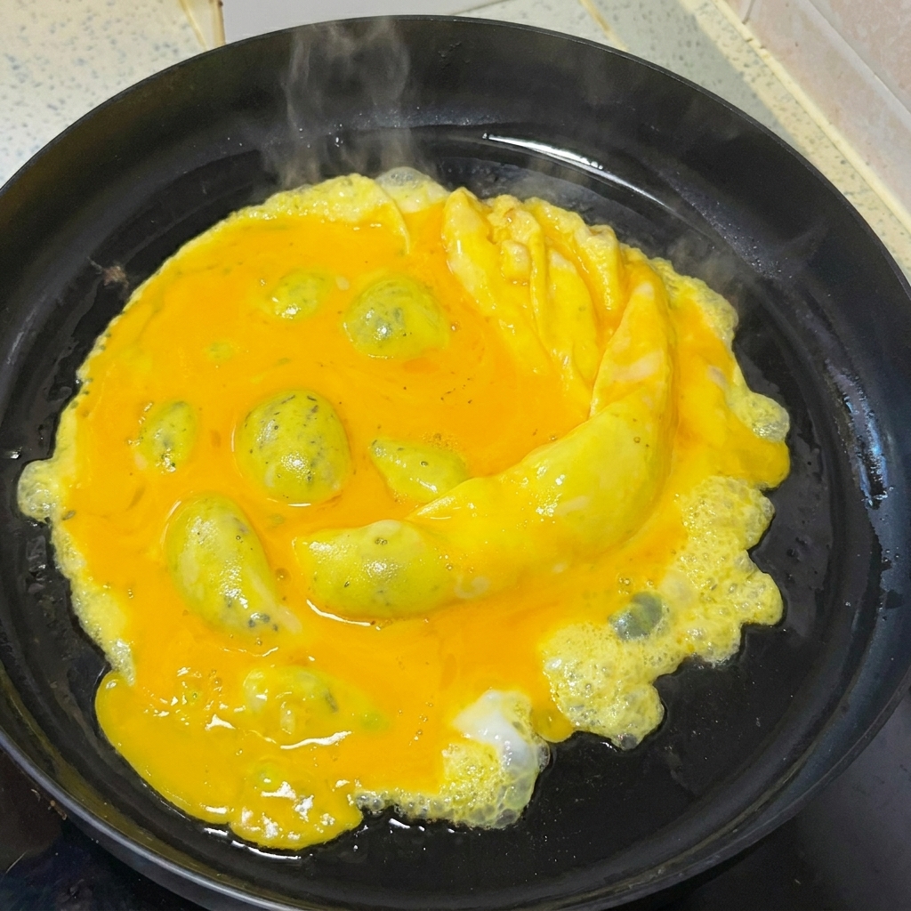 Eggs being gently scrambled in a frying pan using a wooden spatula.