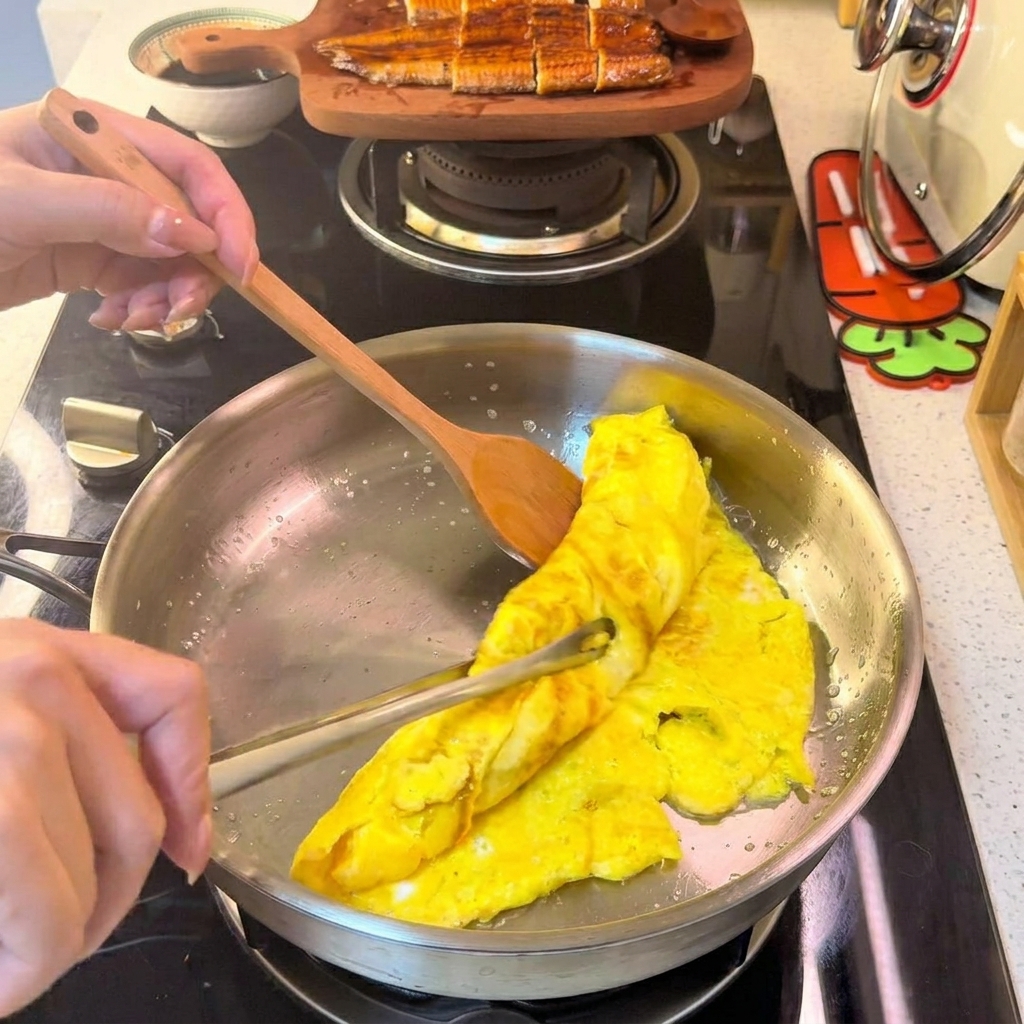 A rolled egg omelet being cut into thin, uniform strips on a white plate.