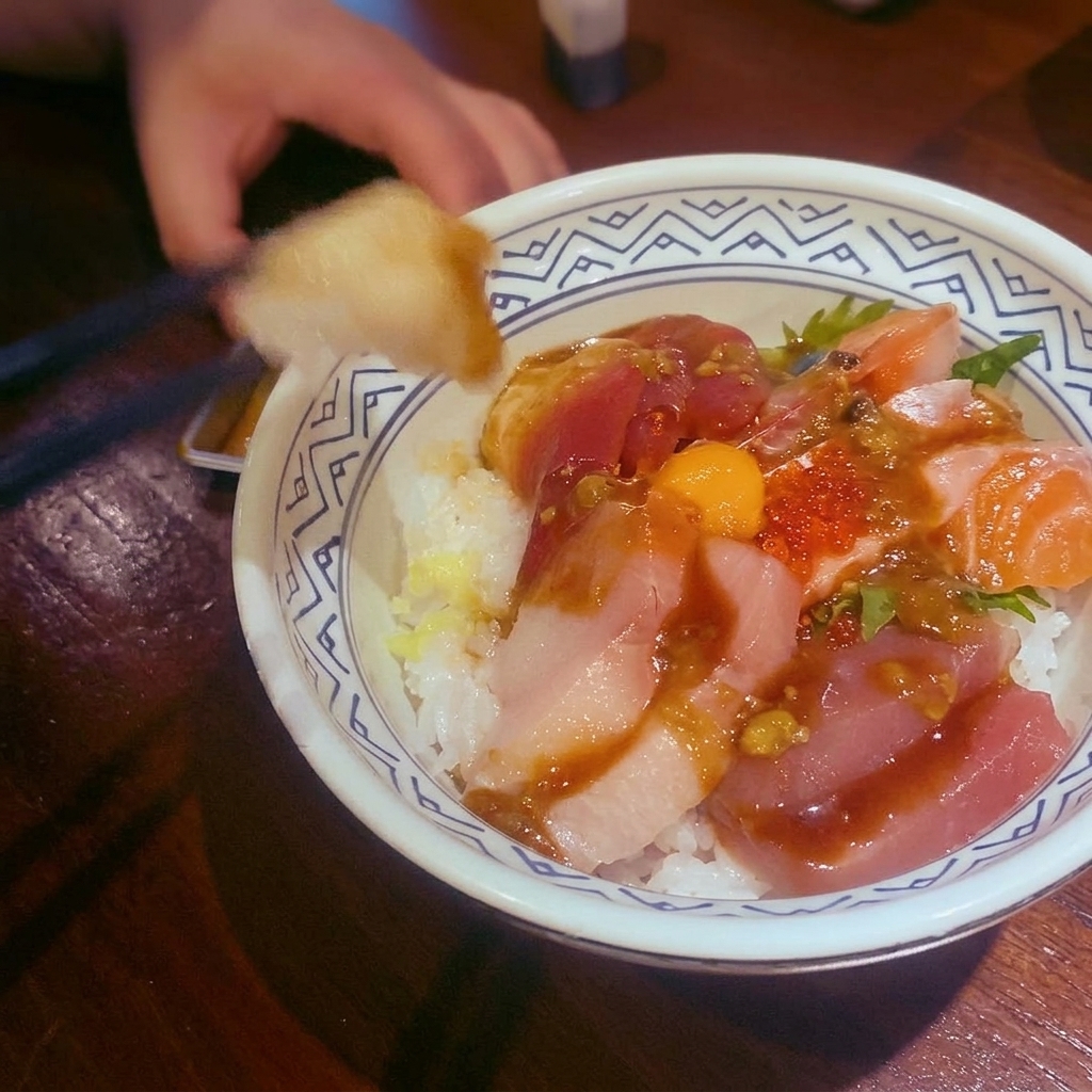 A bowl of red curry sauce served over protein and garnished with lime leaves.