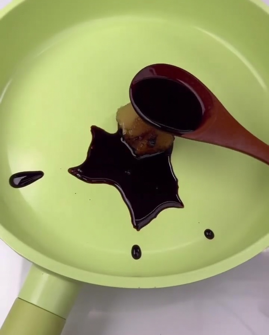 Glaze ingredients, including soy sauce and garlic, being combined in a green pan.