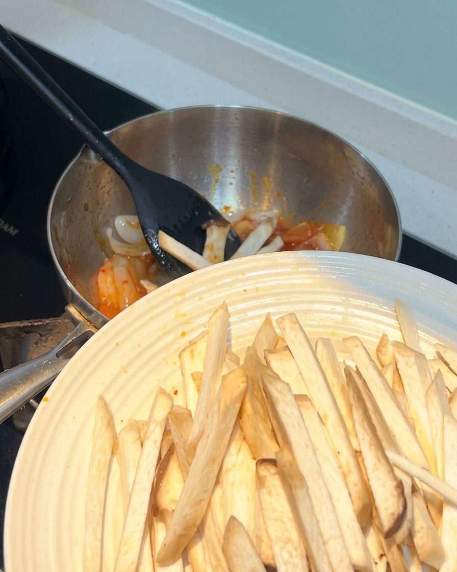Strips of king oyster mushroom being added to the pot.