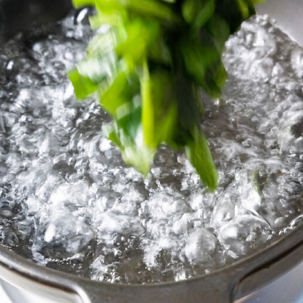 Wakame and tofu cubes being added to a pot of boiling water.