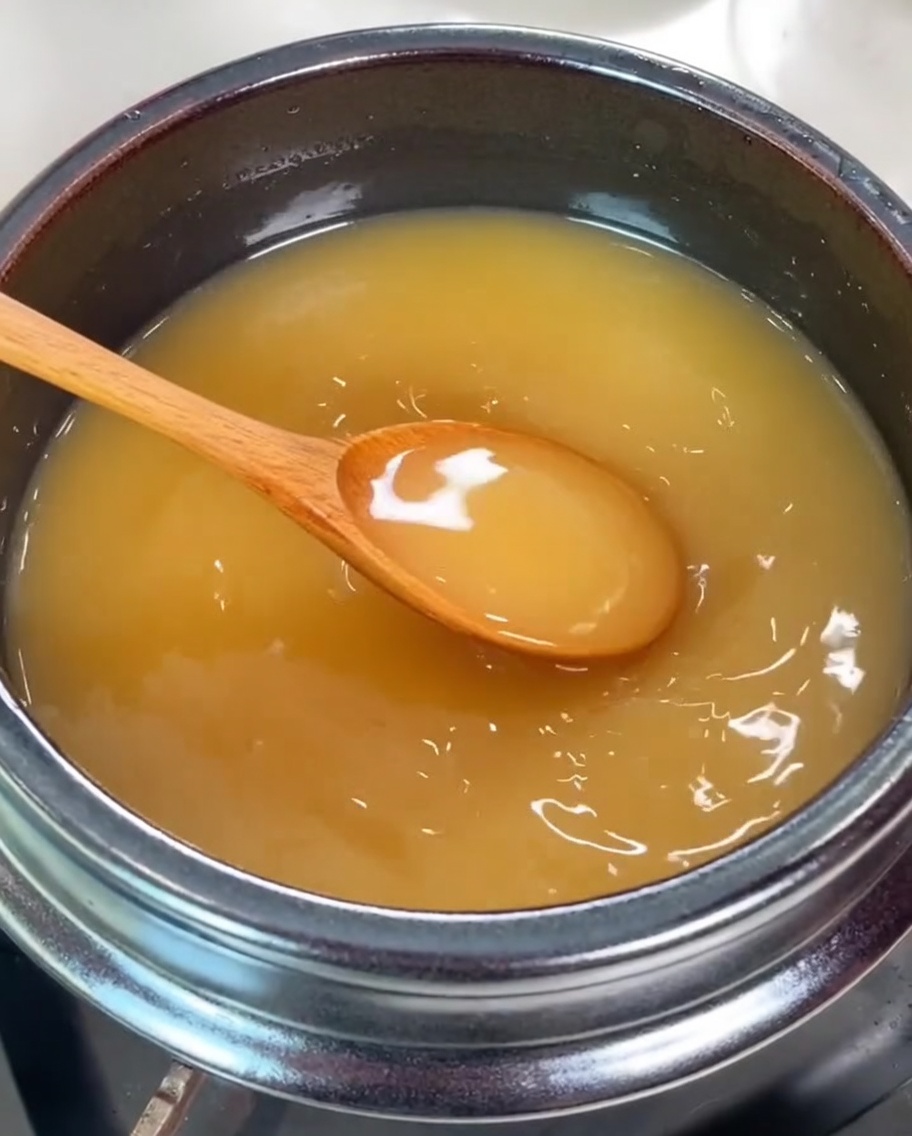 Several fresh clams being added into the pot of soybean broth.