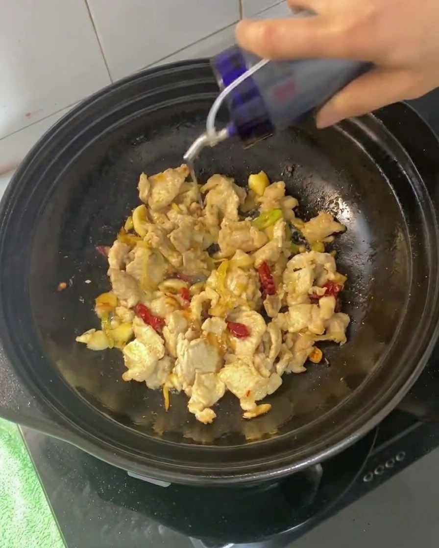 Soy sauces and oyster sauce being added to the stir-fried pork mixture.