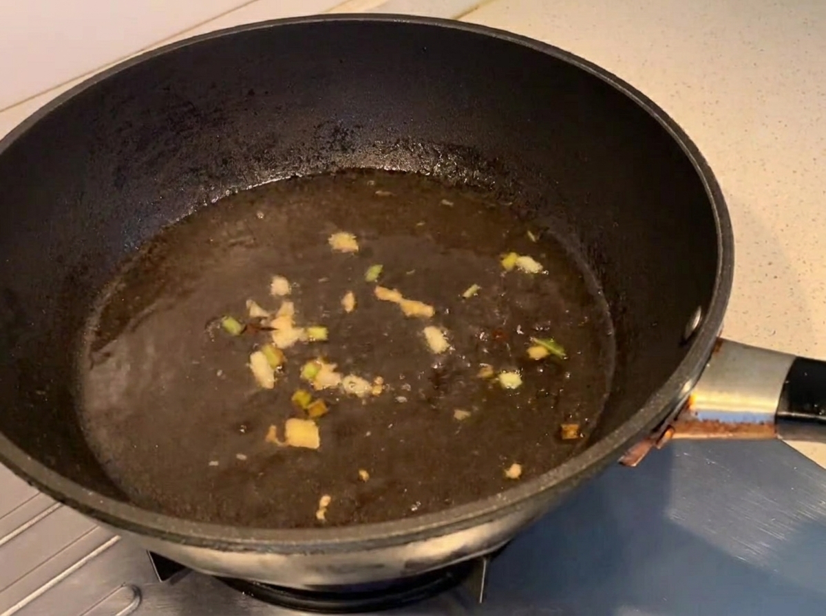 Seasonings being stirred into the boiling liquid in a pan.
