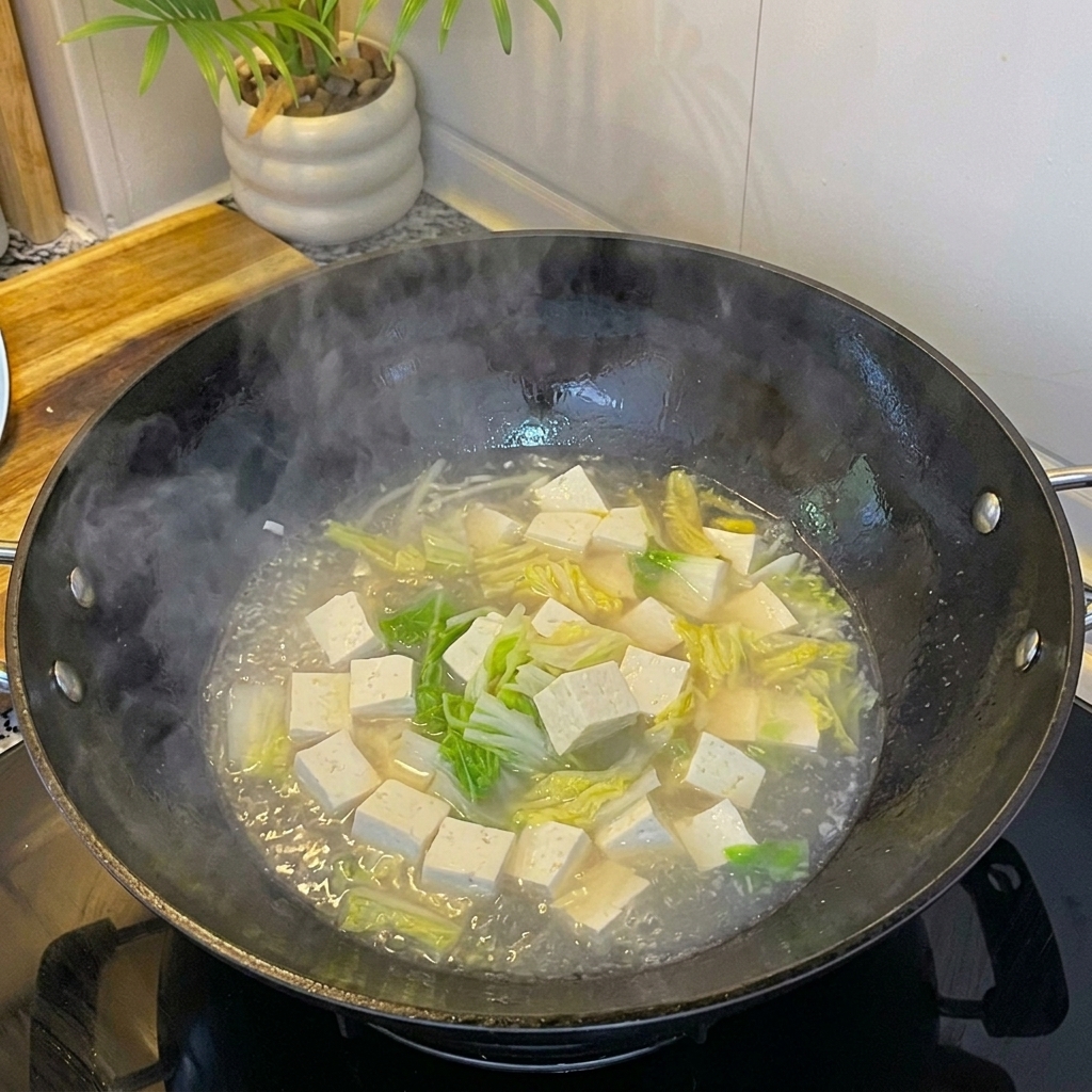 Fresh white clams added to the simmering soup with tofu and egg.