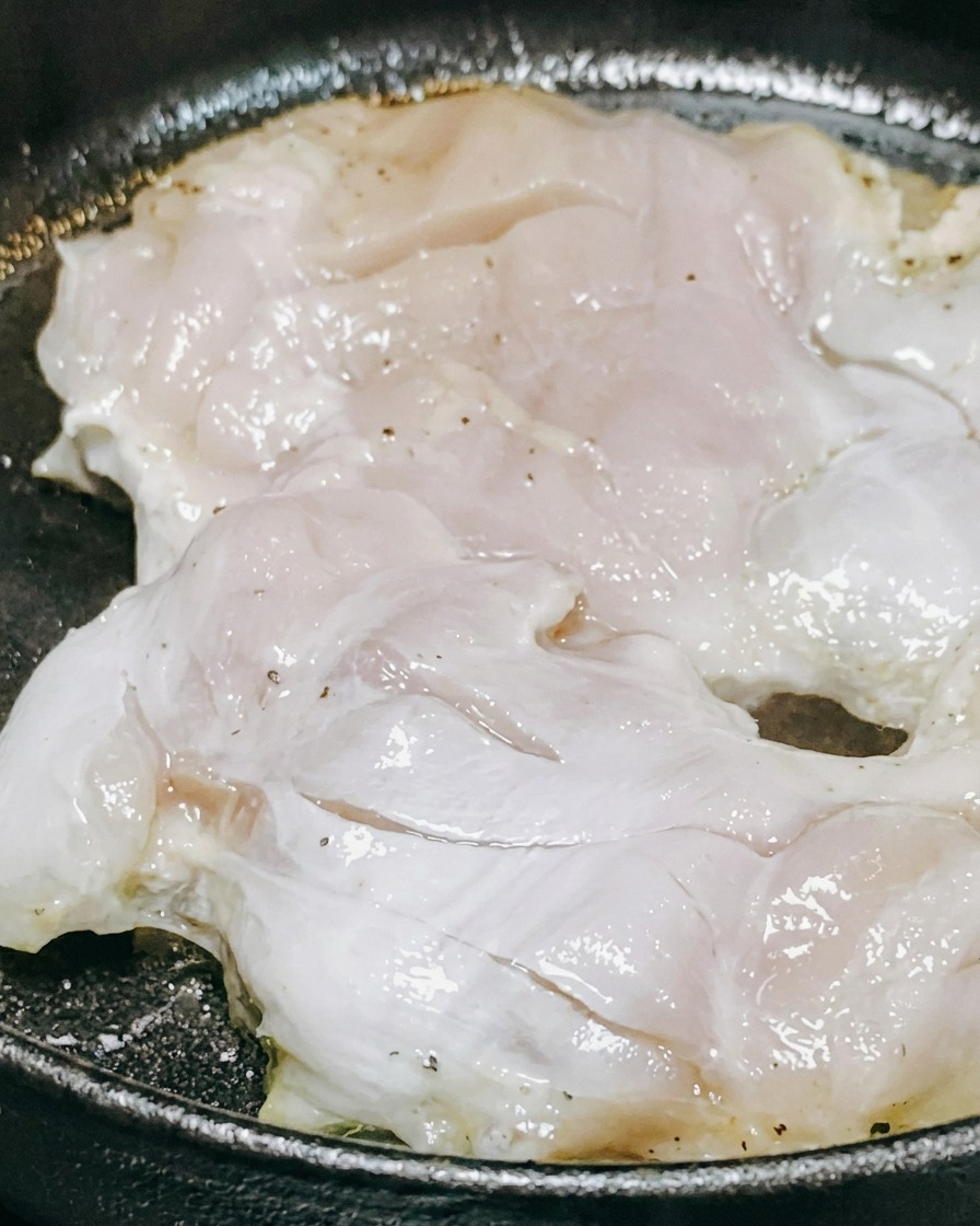 Teriyaki sauce and white wine being poured over chicken pieces cooking in a pan.