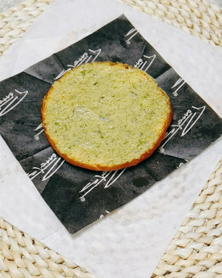 A piece of glistening teriyaki chicken placed on top of the sauce-coated bottom burger bun.