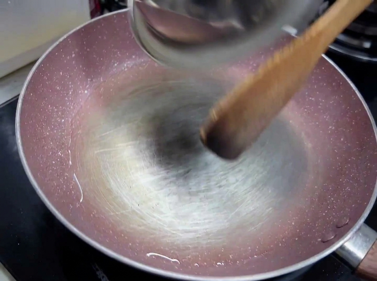 Minced garlic and diced white onion sautéing in a light coating of olive oil in a pan.