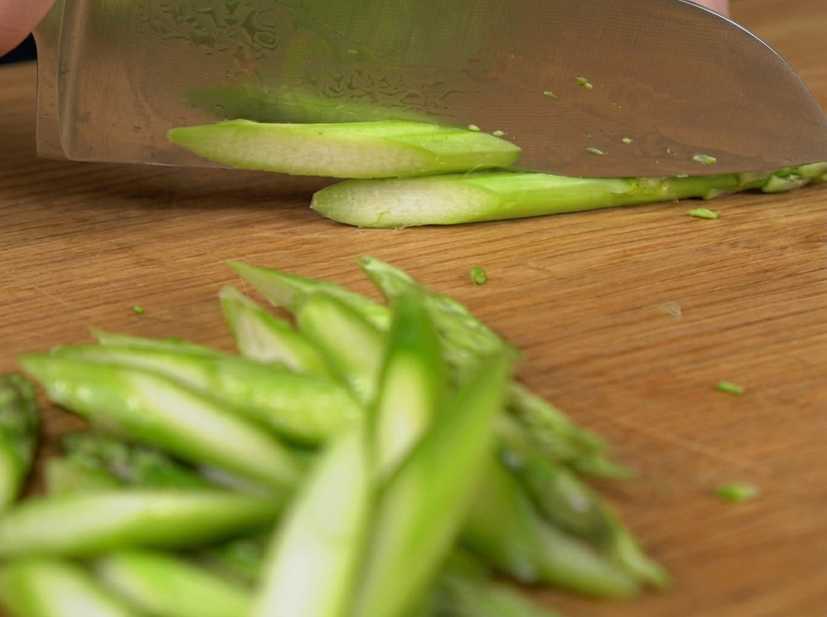Fresh green peas falling into a pot of bubbling hot water.