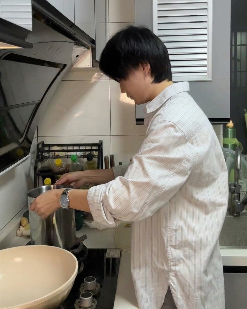 Spaghetti pasta submerging into a large pot of boiling water.