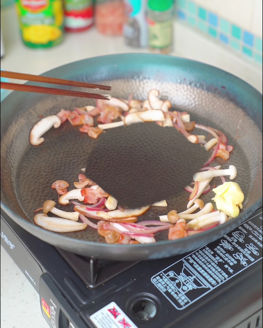 A piece of butter melting into the bacon, mushroom, and onion mixture.