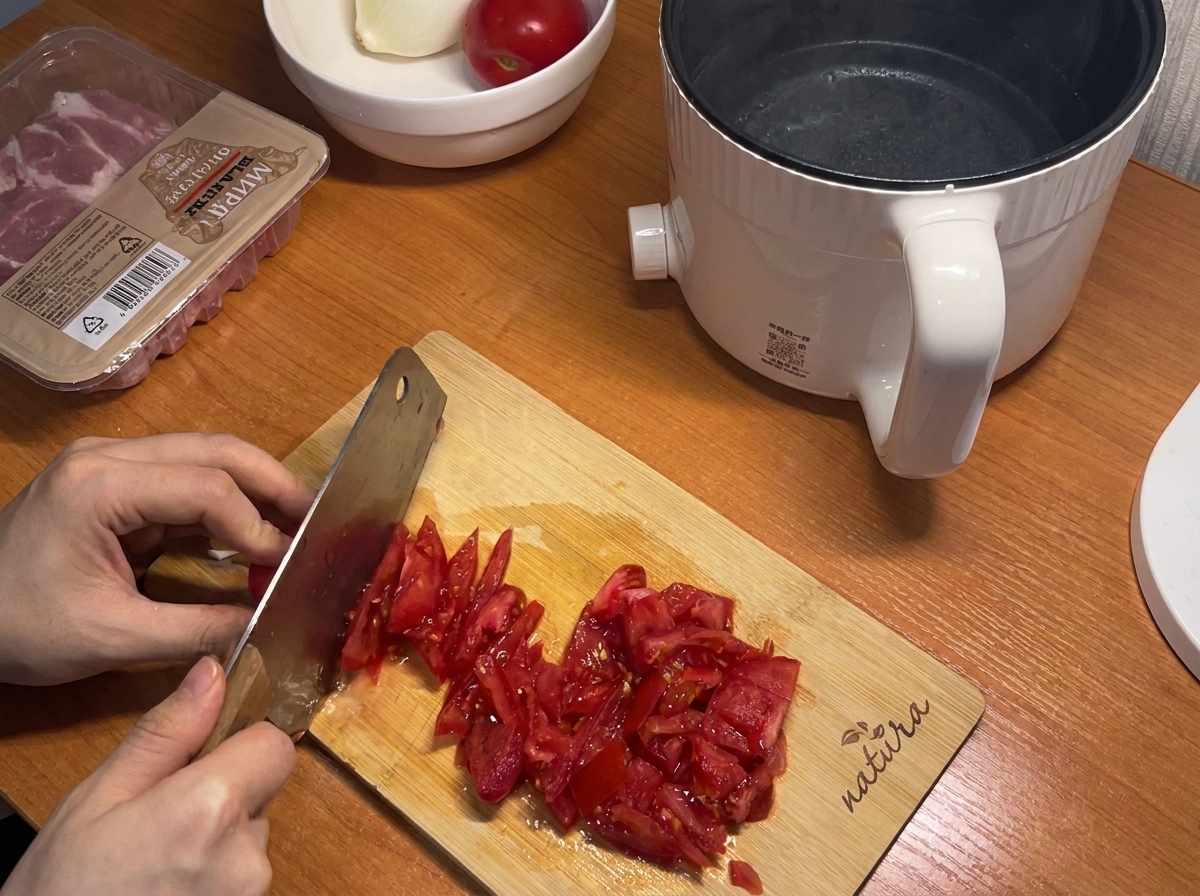 Fresh red tomatoes being chopped into small pieces on a wooden cutting board, ready for the sauce.