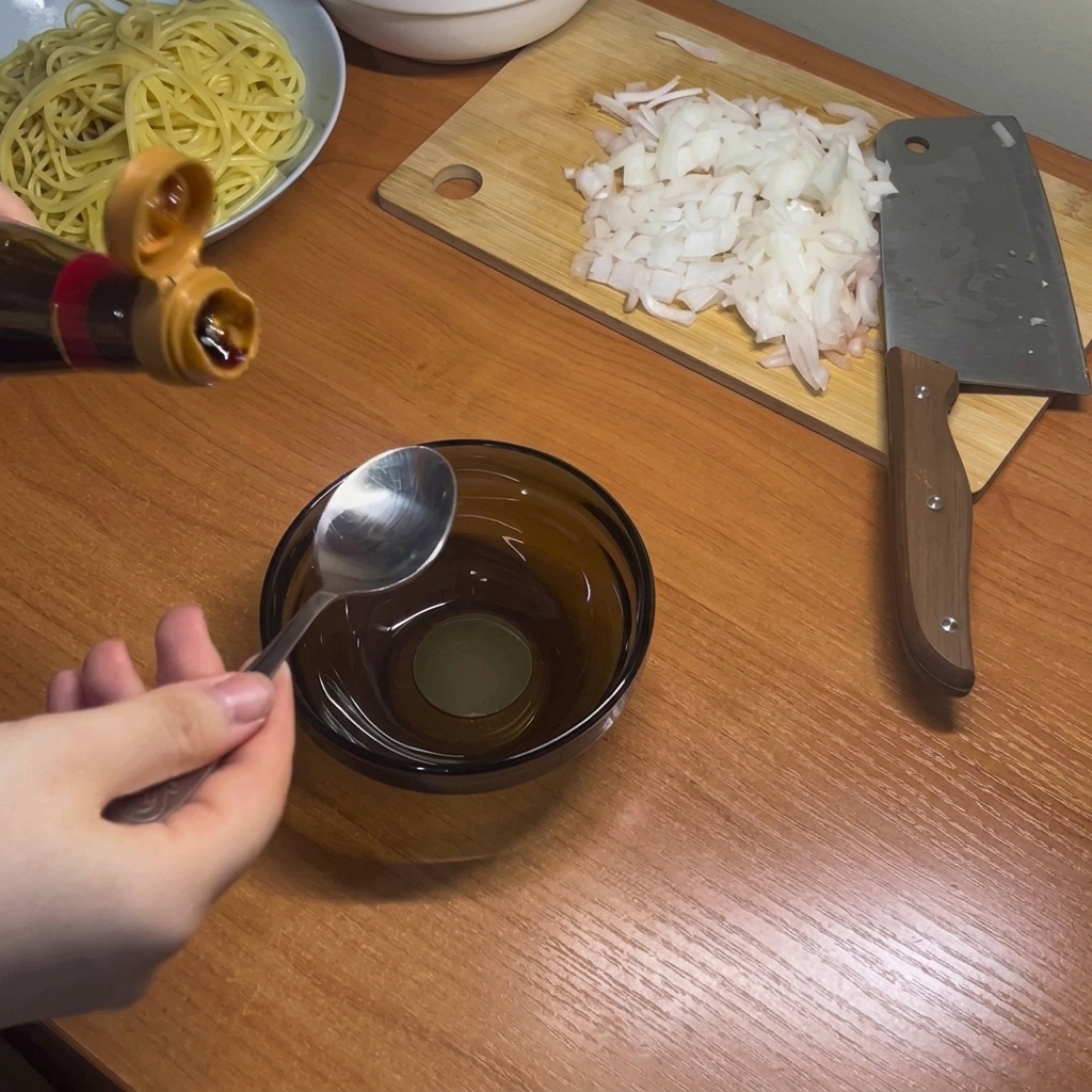 Dark liquid seasonings including soy and oyster sauces being mixed in a small glass bowl.