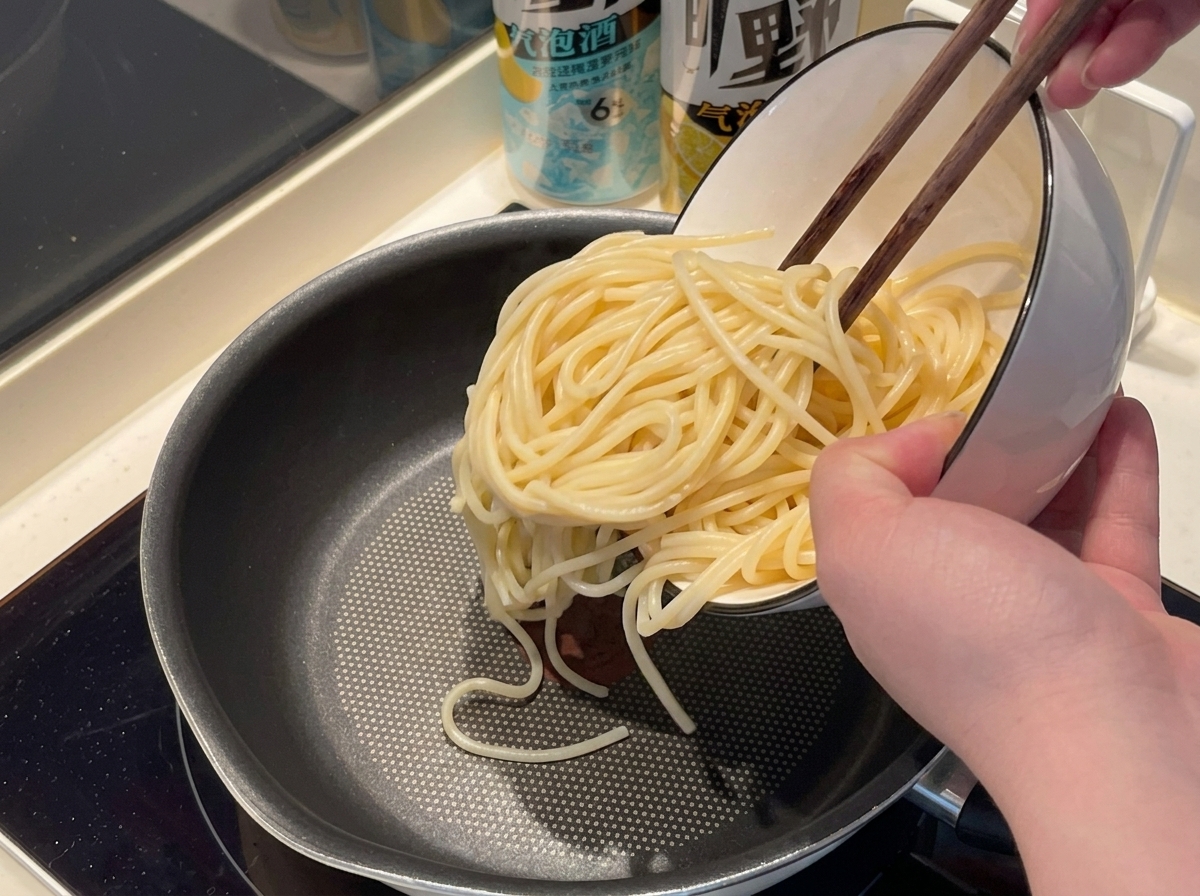 Spaghetti noodles being added to boiling water in a pot.