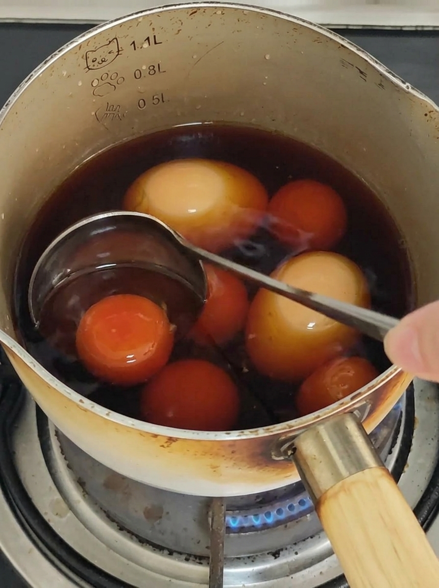 Spaghetti being stirred with chopsticks in a pan to coat with sauce.