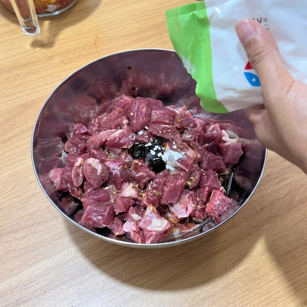 The beef cubes being thoroughly mixed with the liquid seasonings and spices in the bowl.