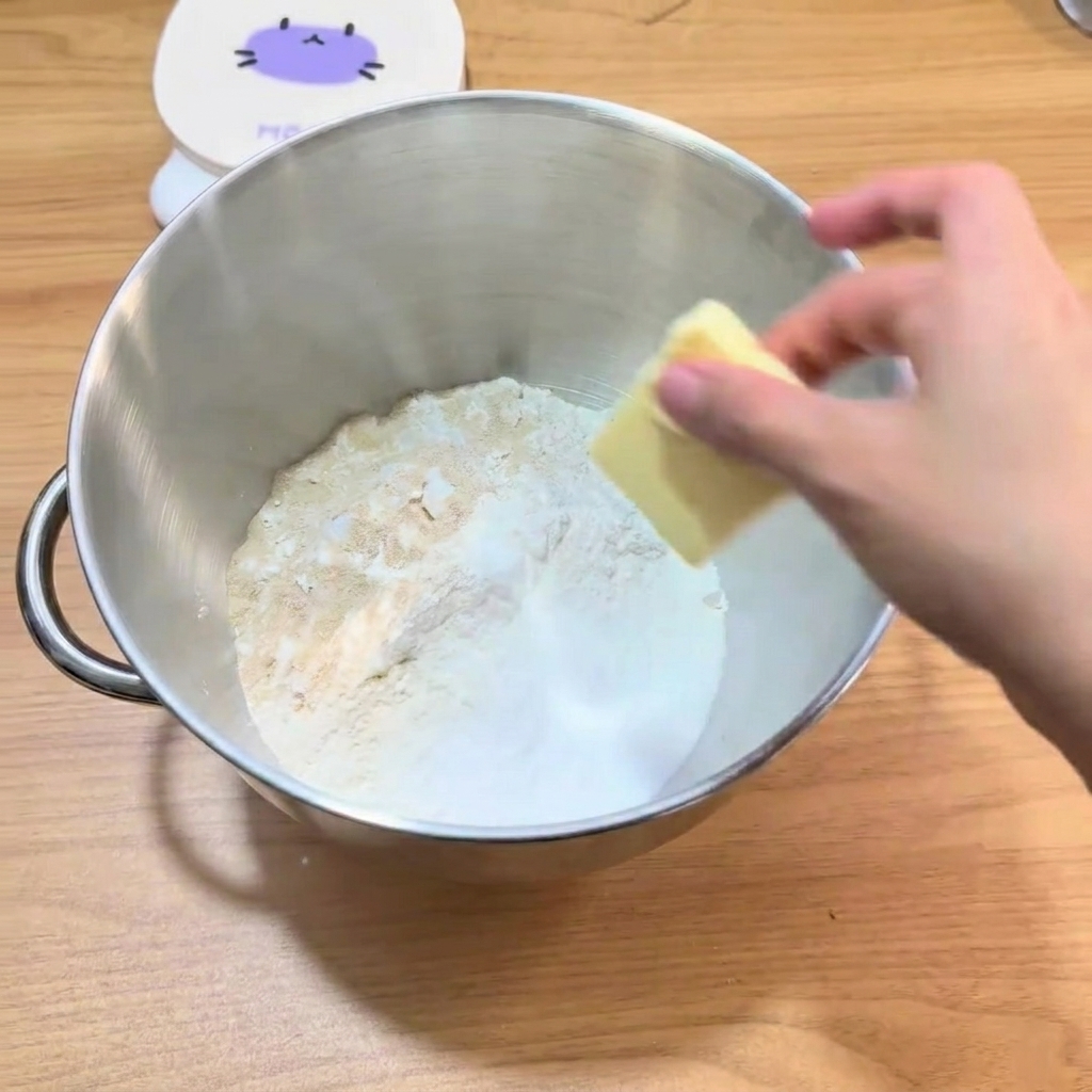 The ingredients inside the mixer bowl, ready to be kneaded into dough.