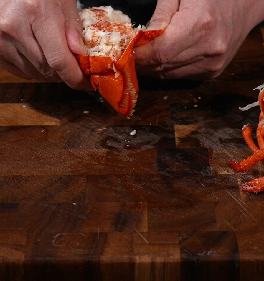 Cooked lobster meat being removed from the shell.