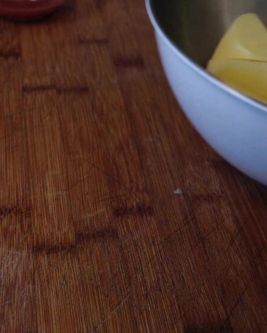 A close-up of potato chunks boiling in a large pot of water on the stove.