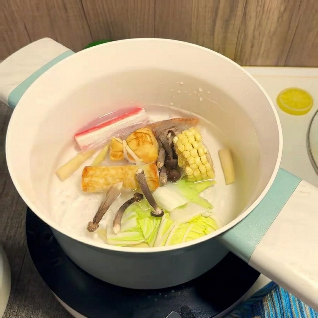 Colorful ingredients like corn and shrimp cooking in a pot of boiling water.