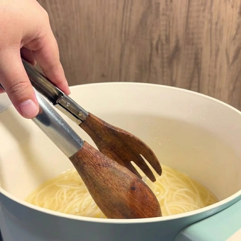 Hot, yellow buttery corn broth being ladled into a clear glass.