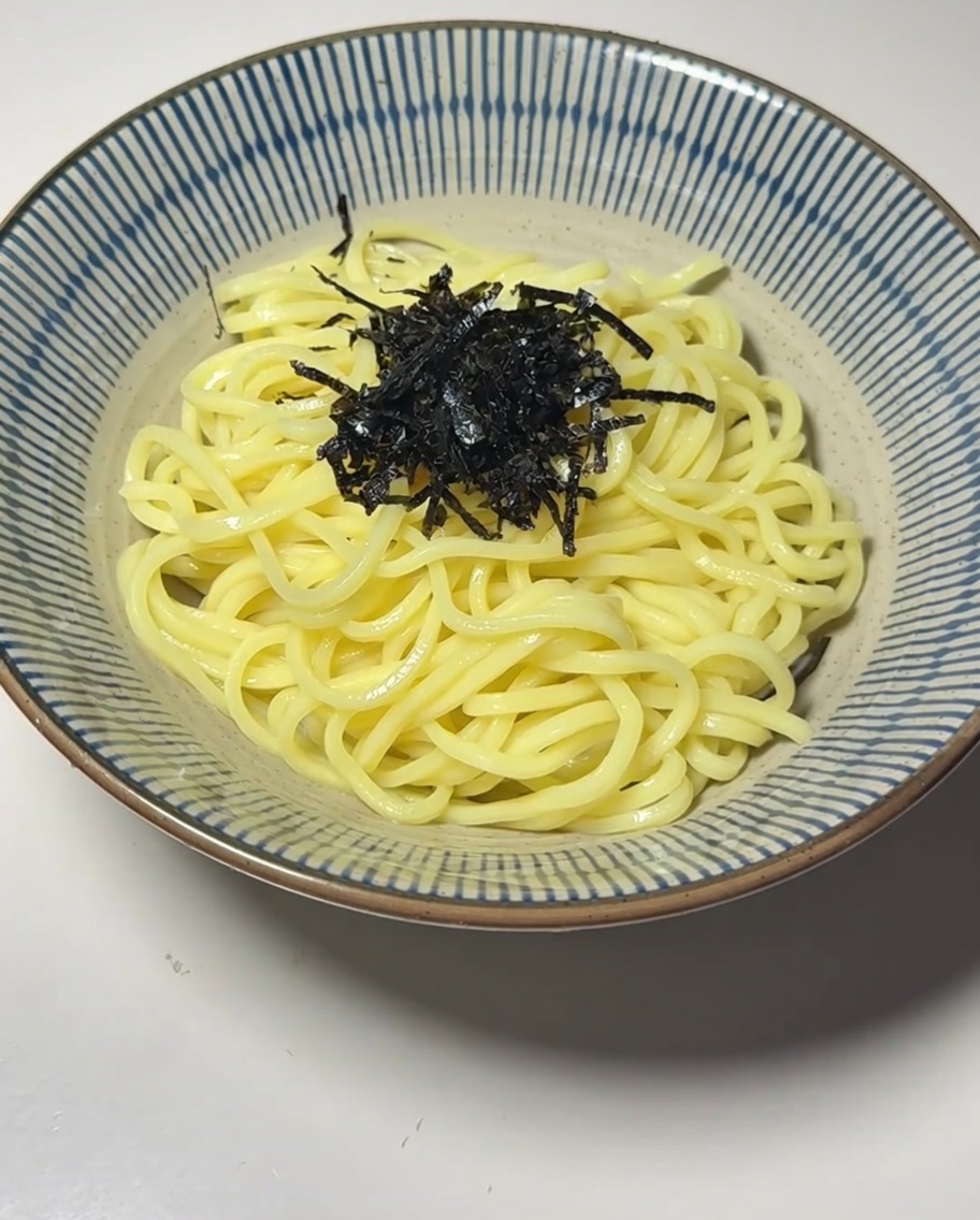 A bowl of noodles topped with seaweed, a soft-boiled egg, and bamboo shoots.