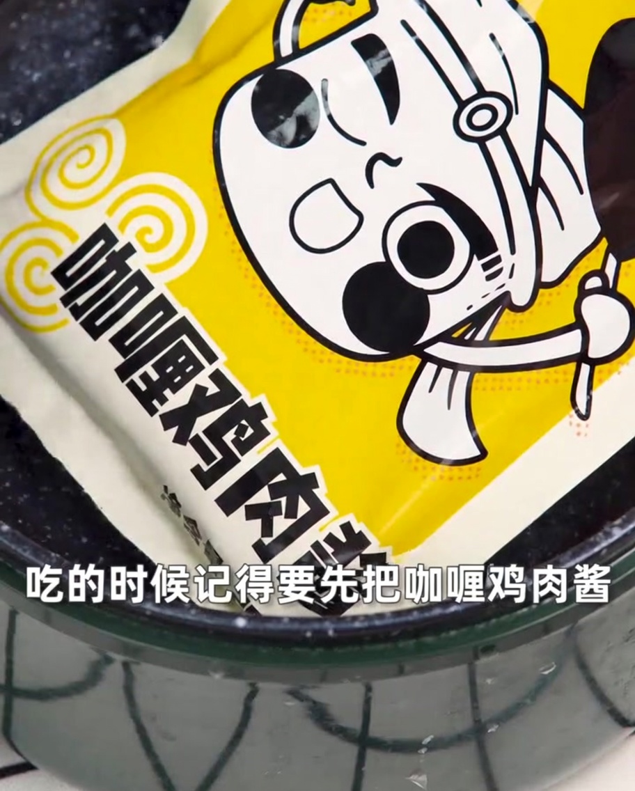 A sealed pouch of curry chicken sauce submerged in a pot of boiling water.