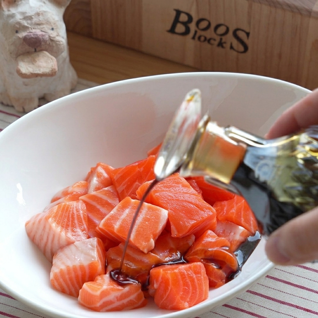 A bowl of fresh raw salmon cubes with various sauces being poured over them.