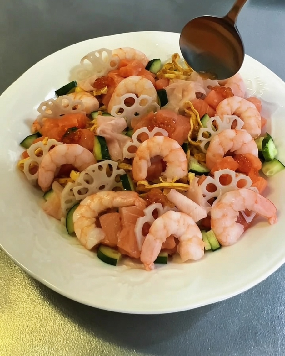A close-up view of vibrant orange fish roe being garnished onto the salmon pieces.